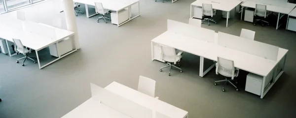 Vue aérienne d'un bureau moderne avec plusieurs écrans affichant des graphiques colorés et un analyste examinant des données marketing